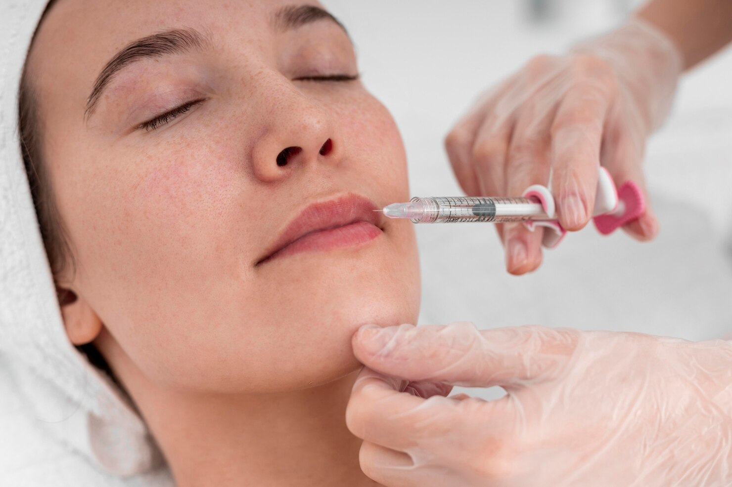 Dermatologist performing a filler injection on a female client in a dermatology clinic, providing advanced cosmetic treatments for facial rejuvenation and skin enhancement in a professional setting.