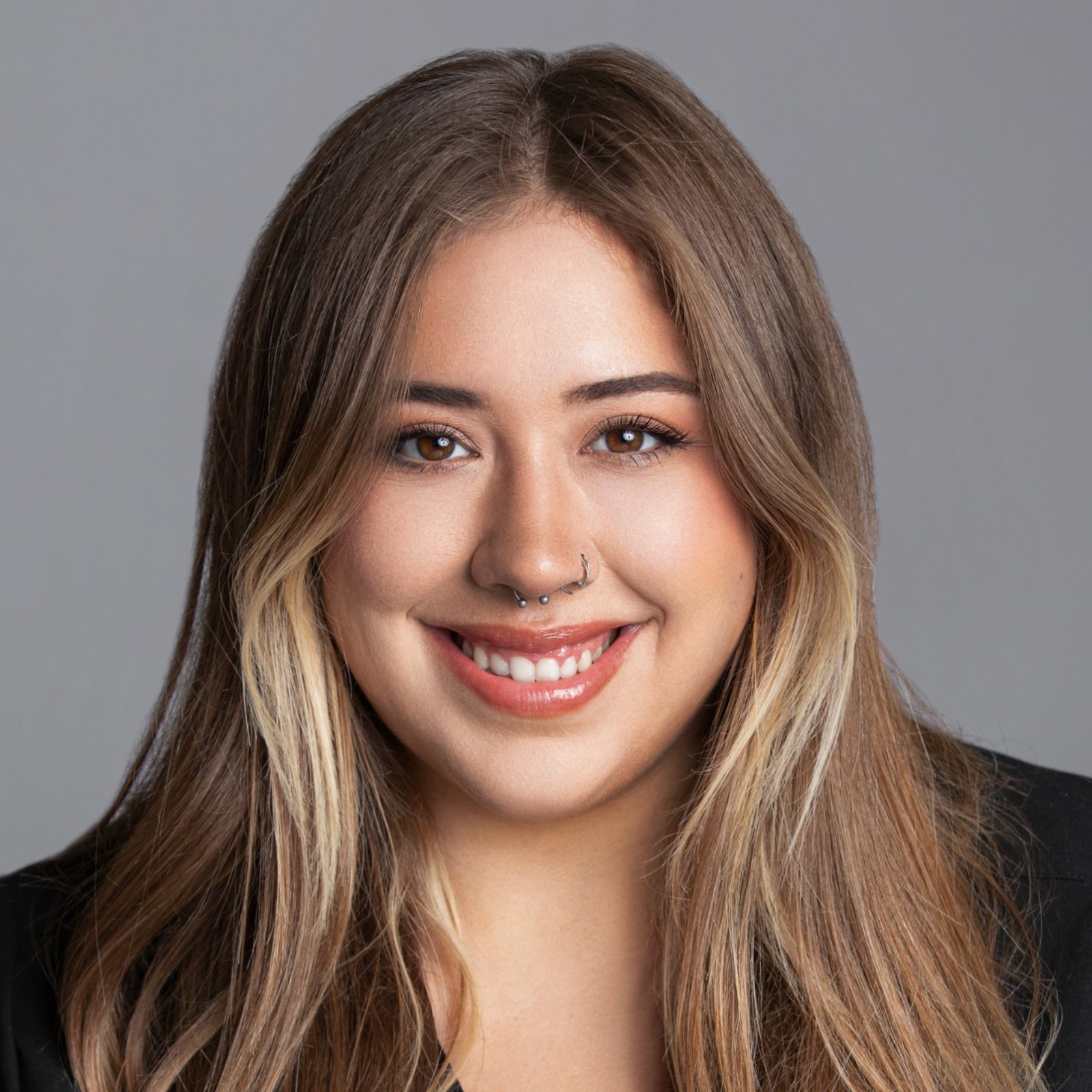 Sarah Mohammed, Patient Coordinator & Aesthetician, wearing medical scrubs and smiling at the camera. This professional portrait showcases her role in patient care and aesthetic treatments at a cosmetic dermatology clinic.